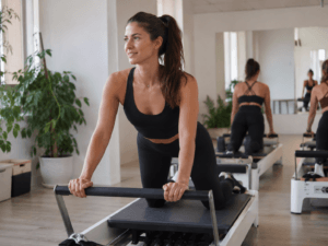 Jeune femme a un cours de pilates reformer