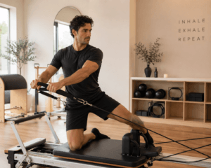 Jeune homme fait du Pilates reformer en studio